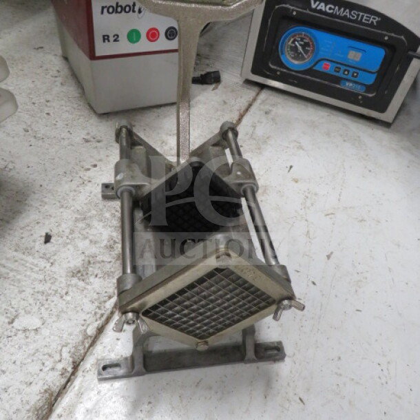 Heavy-duty metal potato cutter with grid blade, mounted on a sturdy base. Shows light wear, ideal for commercial use.