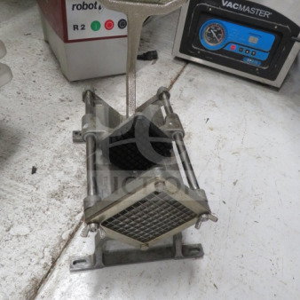 Heavy-duty metal potato cutter with grid blade, mounted on a sturdy base. Shows light wear, ideal for commercial use.