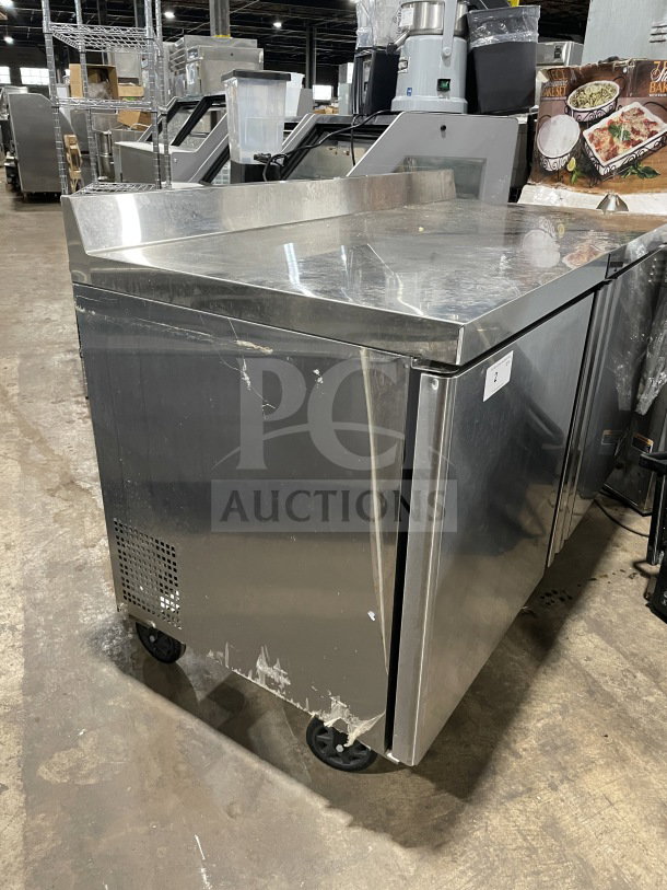 Berg stainless steel 60" 2-door prep table, model BERWT60R, with poly-coated wire rack, visible wear, and caster wheels.