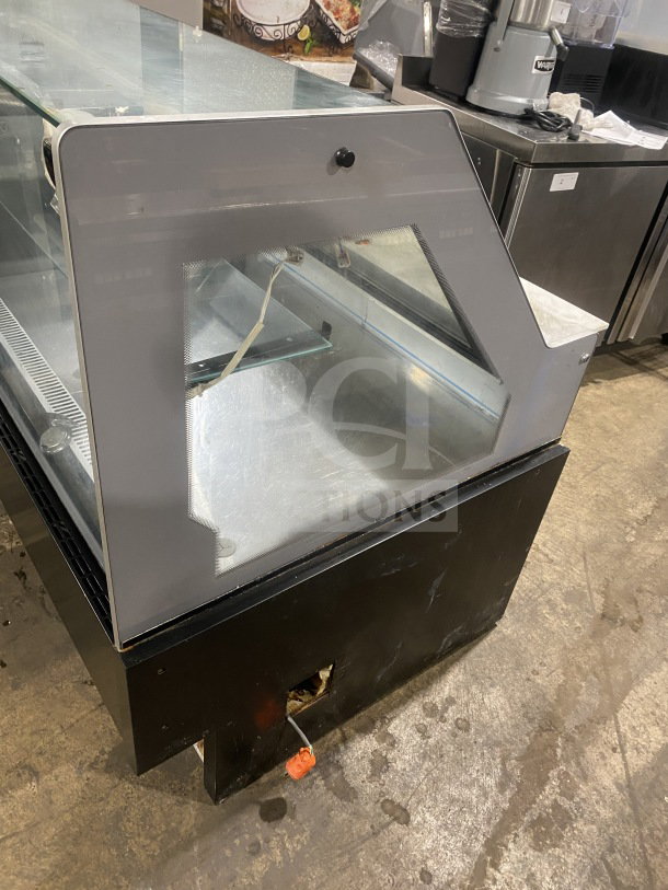 Commercial refrigerated display case with glass shelving, metal finish, and visible wiring. Used condition, potential for repair.