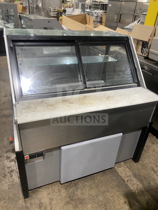 Commercial glass food display case with sliding doors, stainless steel body, and ventilation. Used condition, suitable for deli or bakery.