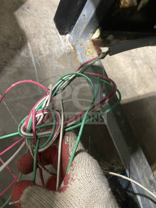 Wiring of Senkar NETA8FT 2021 bakery display case on casters, in used condition with visible rust on the base frame.