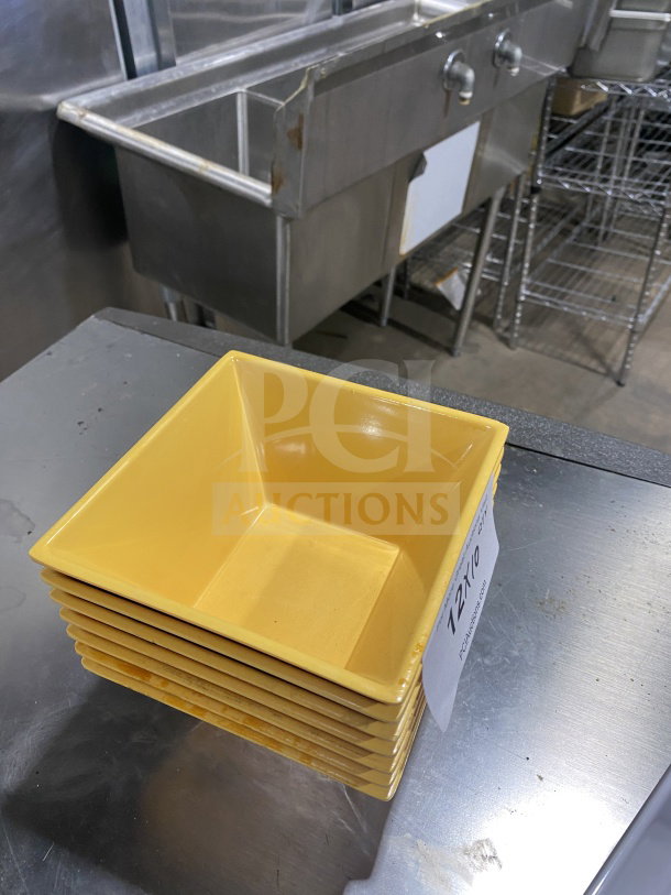 Stack of yellow melamine deep bowls with unique square geometric design, in excellent condition, labeled for auction.
