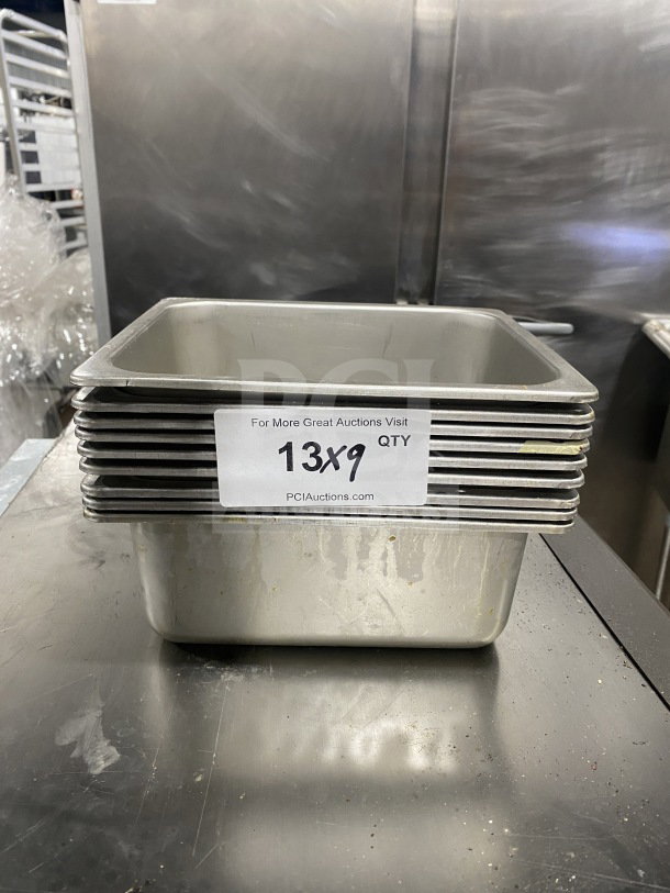 Stack of commercial stainless steel half-size hotel food pans. Condition: used. Label shows "13X9 QTY".