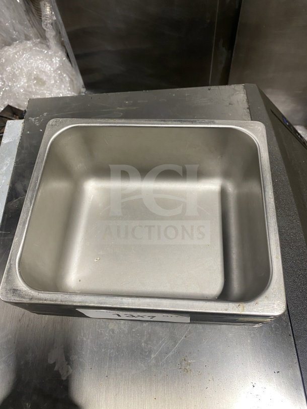Commercial stainless steel half-size hotel food pan, visible wear, measures 13x7 inches.
