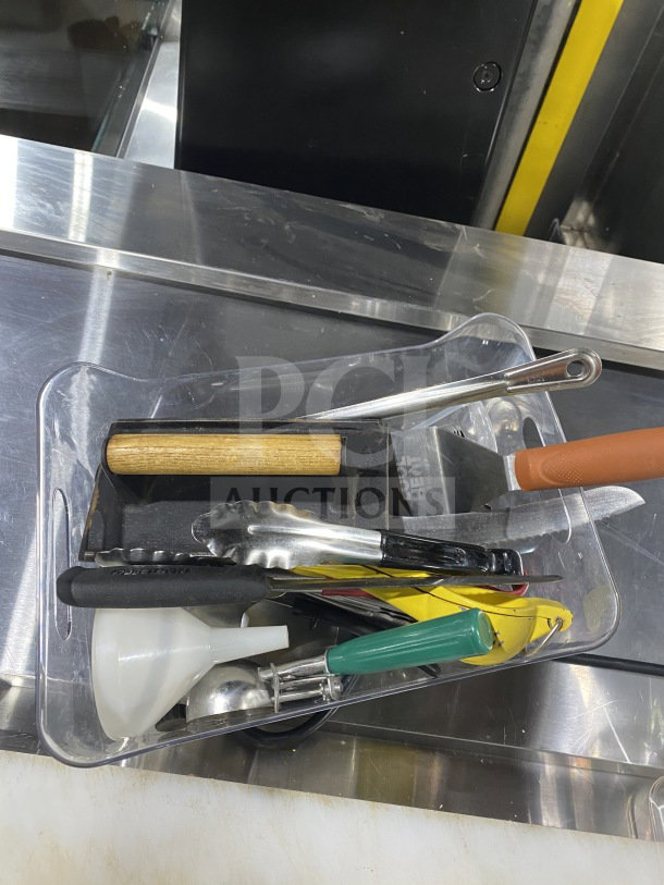 Lot of commercial kitchen smallwares and prep utensils, including scoop, tongs, funnel, knives, and more, in used condition.