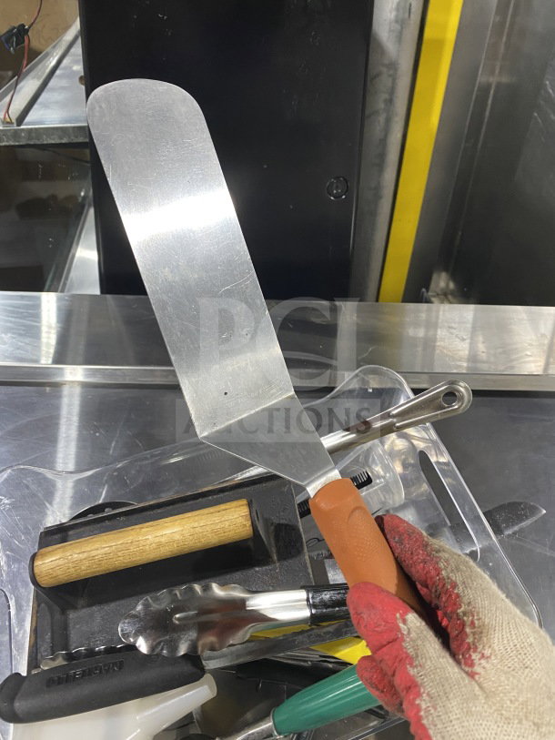 Commercial kitchen smallwares lot including spatula, tongs, and prep utensils. Mixed materials, good condition, sold as one lot.