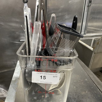 Commercial kitchen smallwares and prep utensils lot in a clear container. Includes tongs, grater, and spoons. Good condition.