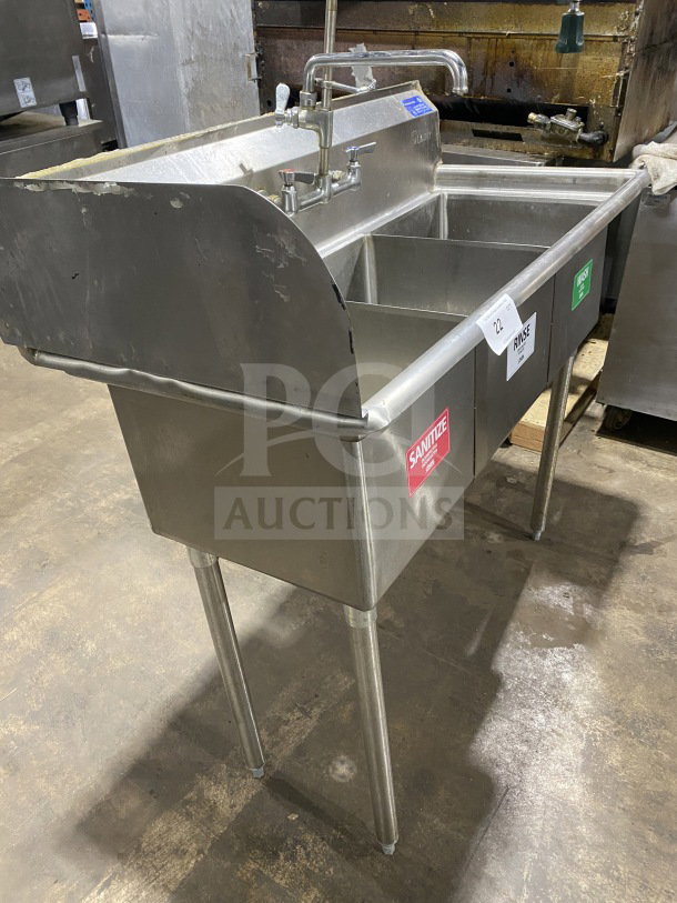 L&J stainless steel 3-bay dishwashing sink with dual drain boards, on legs. Features wash, rinse, sanitize sections.