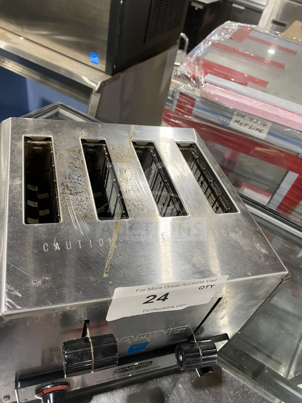 Waring Commercial stainless steel 4-slice toaster, Model WCT800, with visible wear, caution label, and auction tag on surface.