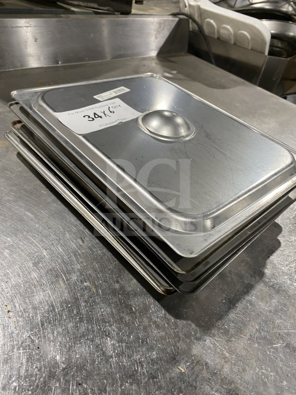 Winco commercial stainless steel half-size steam table pan covers, model SPSCH, stacked. Visible label with quantity.