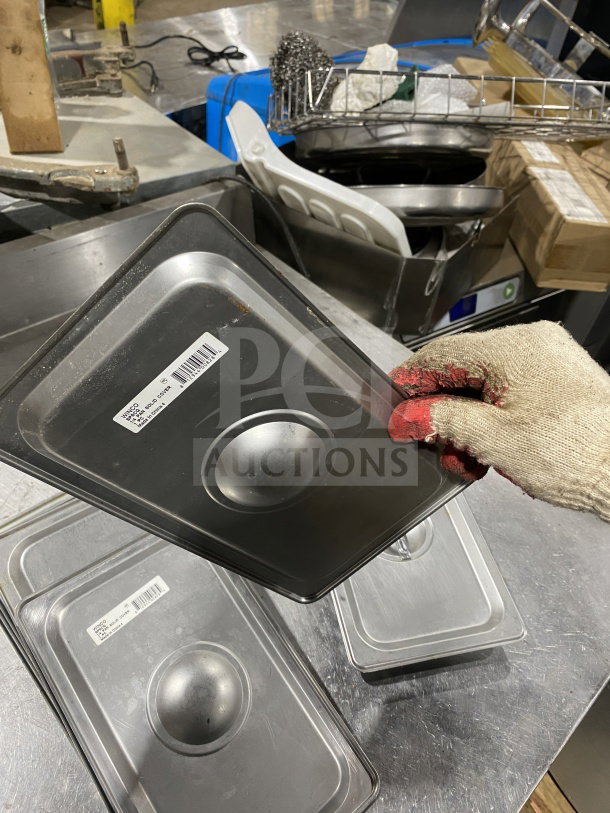 Winco SPSCQ stainless steel 1/4-size steam table pan cover with recessed handle shown in a commercial setting.