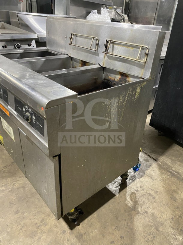 Frymaster FMPH255SC commercial stainless steel dual deep fat fryer with left side dumping station, backsplash, and filter system on casters.