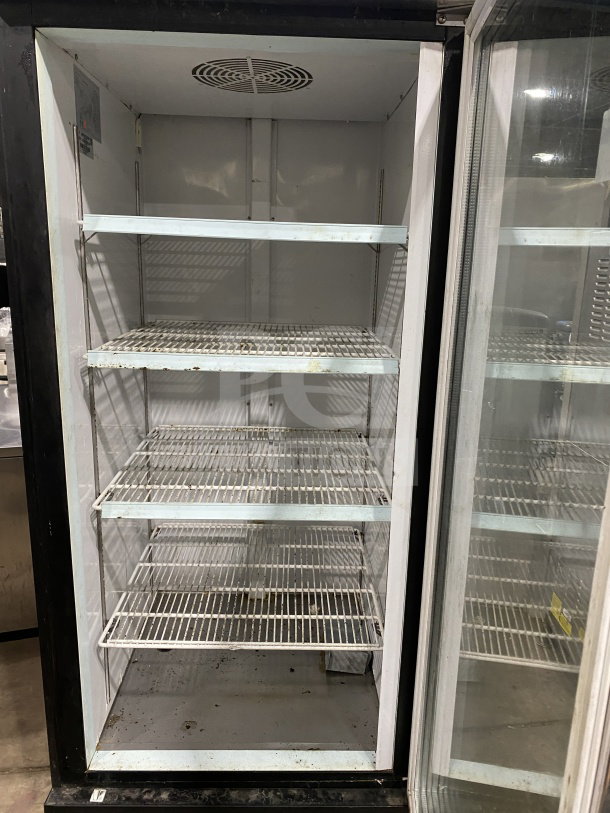 Kelvinator Commercial 28" freezer, model KCGM24FB, with swinging door, bottom mount compressor, and wire racks on casters.