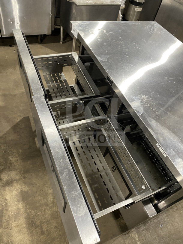 True TUC-48F-D-4-HC stainless steel 4-drawer undercounter freezer with marble-style worktop, upturned backsplash, and casters.
