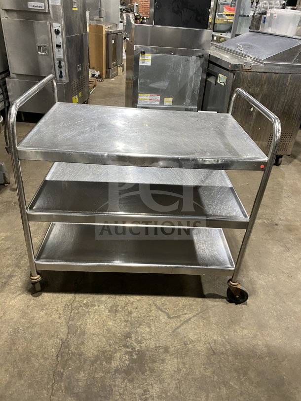 Commercial stainless steel utility trolley with three compartments on casters, used condition, ideal for kitchen or storage use.