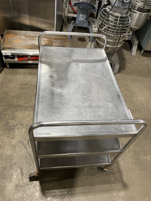Commercial stainless steel utility trolley with three compartments, on casters for mobility; sturdy and in good condition.