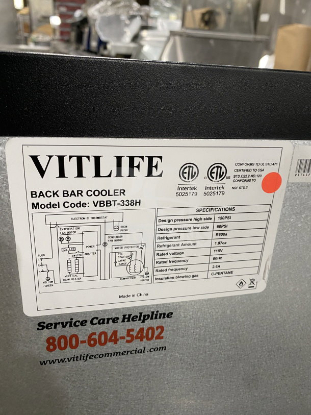 Vitlife VBBT-338H three-door glass cooler, chrome rack, on casters, service helpline info visible, ETL certified label.