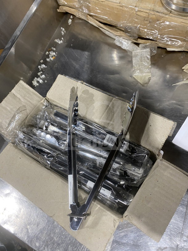 Stanton Commercial 9" stainless steel scalloped tongs, new in packaging, box of 12, "Made in China" label visible.
