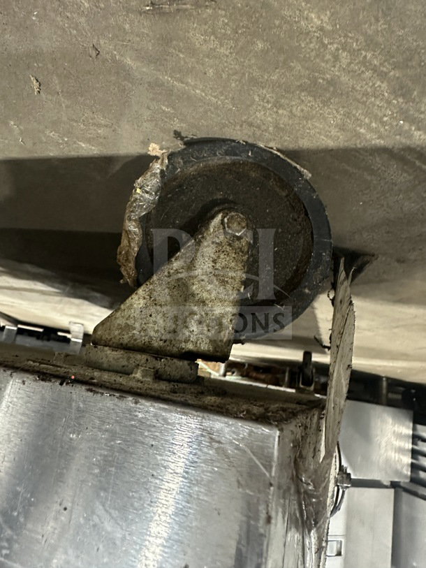 Beverage Air WTRCS60-1 fridge castor wheel close-up, showing wear and use. Model and make info partially visible.