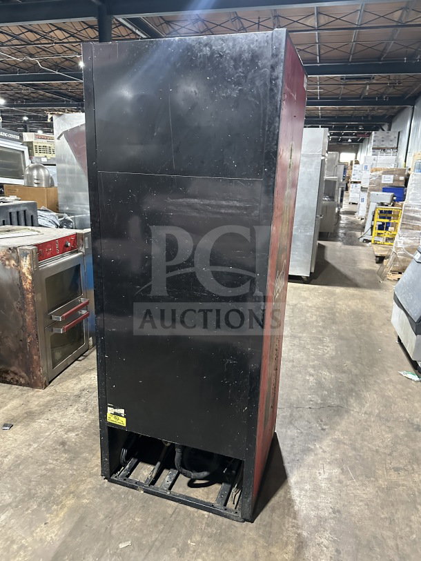 Black True GDM-26EM commercial Coca-Cola style single glass-door refrigerated merchandiser with poly-coated rack. Condition shows signs of use. Model and serial number tags visible.