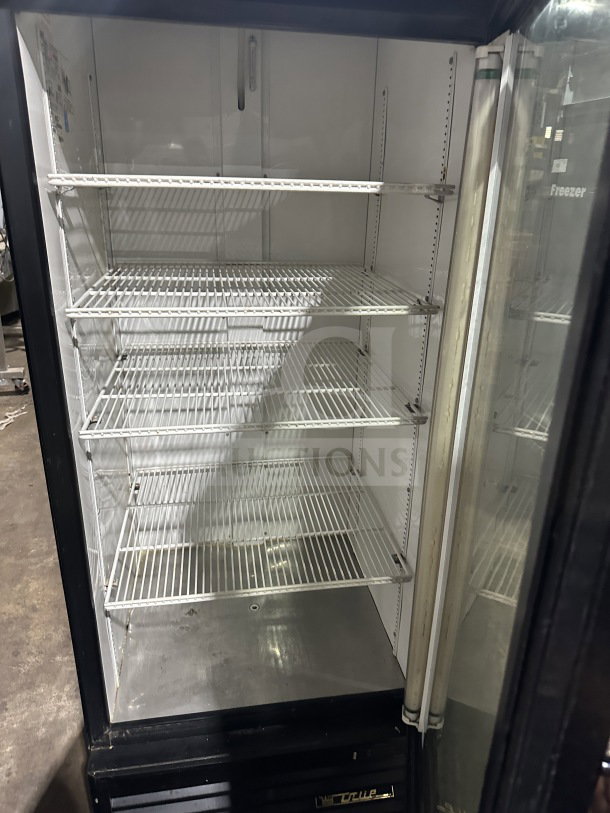 True Commercial Coca-Cola style black refrigerated merchandiser, Model GDM-26EM, with glass door and poly-coated wire racks.