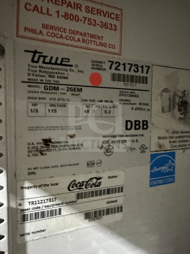 True GDM-26EM Coca-Cola style refrigerated merchandiser tag, model and serial number 7217317, 115V, 1 phase, with service info.