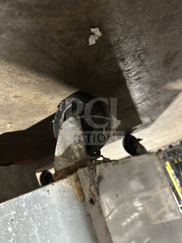 Continental Commercial stainless steel freezer, model 1F, on casters, visible wear and rust on caster base.