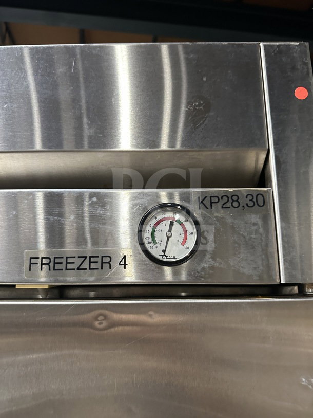 True T72-F commercial stainless steel 3-door freezer with temperature gauge, label "Freezer 4," and poly-coated rack.