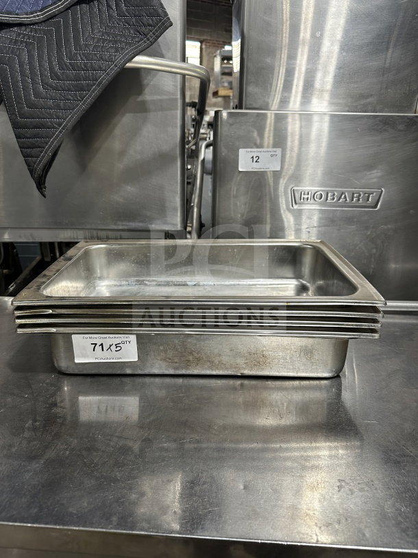 Commercial stainless steel steam table pans, stack of five, lightly used, Hobart brand, auction label "71 x 5 QTY" visible.