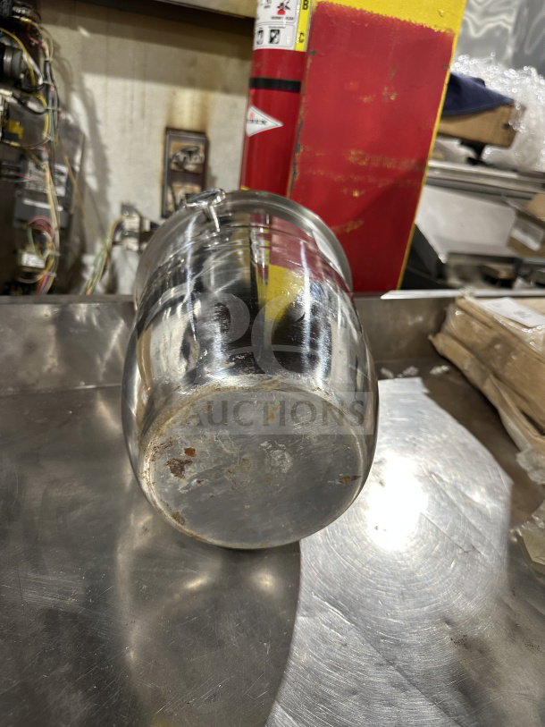 Commercial stainless steel wine bucket with handles, showing signs of rust and wear on the bottom. Suitable for chilling bottles.