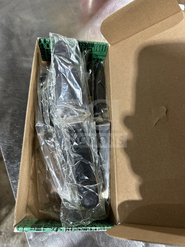 Brand new Dexter Russell S174 stainless steel offset spatula with black grip handle, in original packaging.