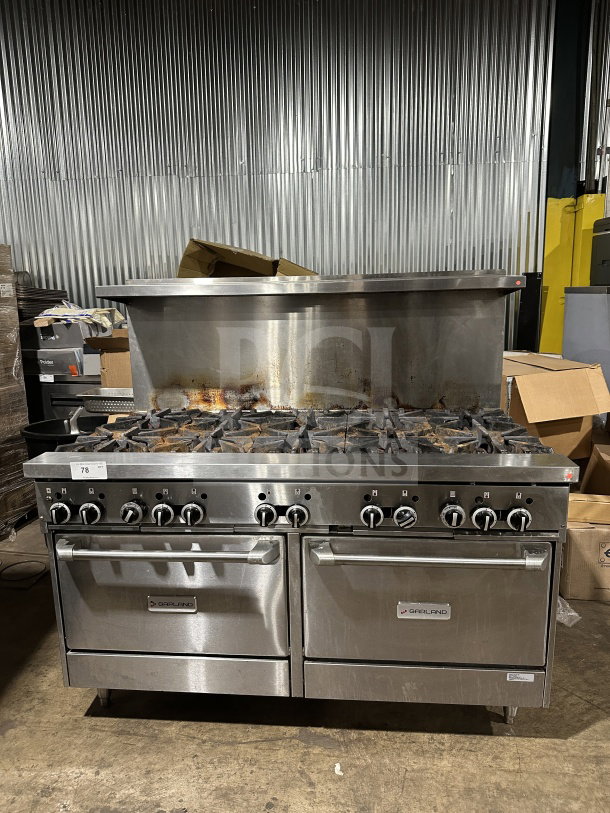 Garland Commercial 10-burner gas range and double oven, stainless steel, with backsplash and wired oven rack, on legs.