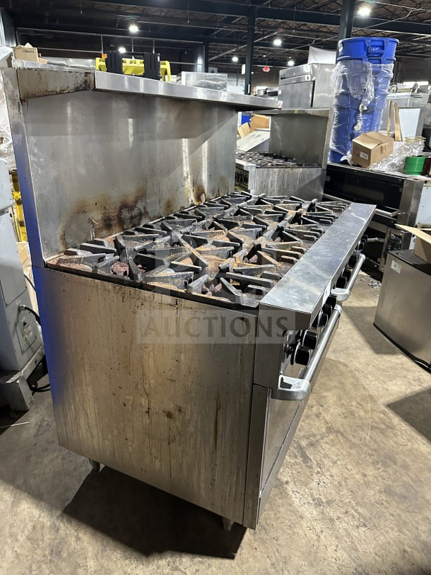 Garland commercial stainless steel gas range, 10 burners, double oven combo, backsplash, wired oven rack, on legs, used condition.
