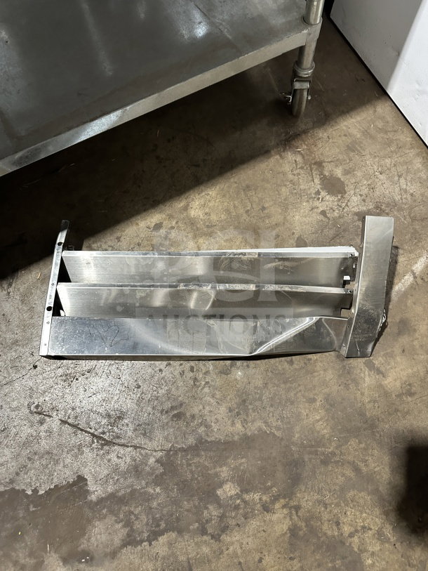 Avantco stainless steel freezer door panel with visible dents, lying on a concrete floor. Model 178SS1FHC.