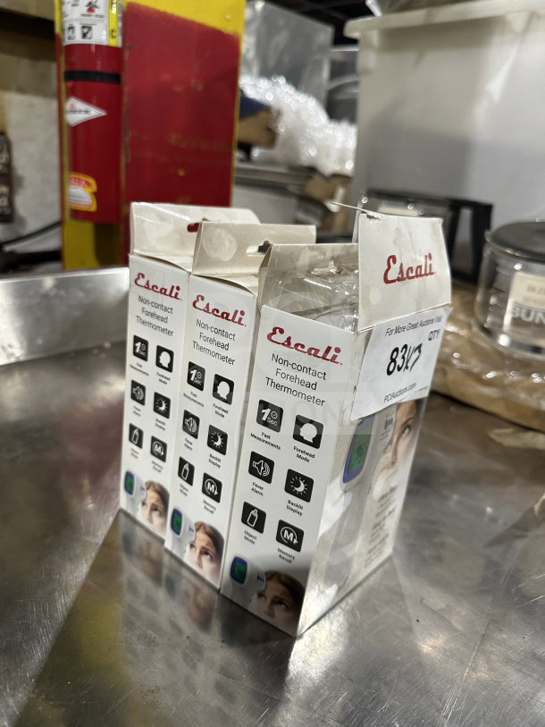 Brand new Escali THDG310 non-contact forehead thermometers in boxes, easy-read backlight display, model markings visible.