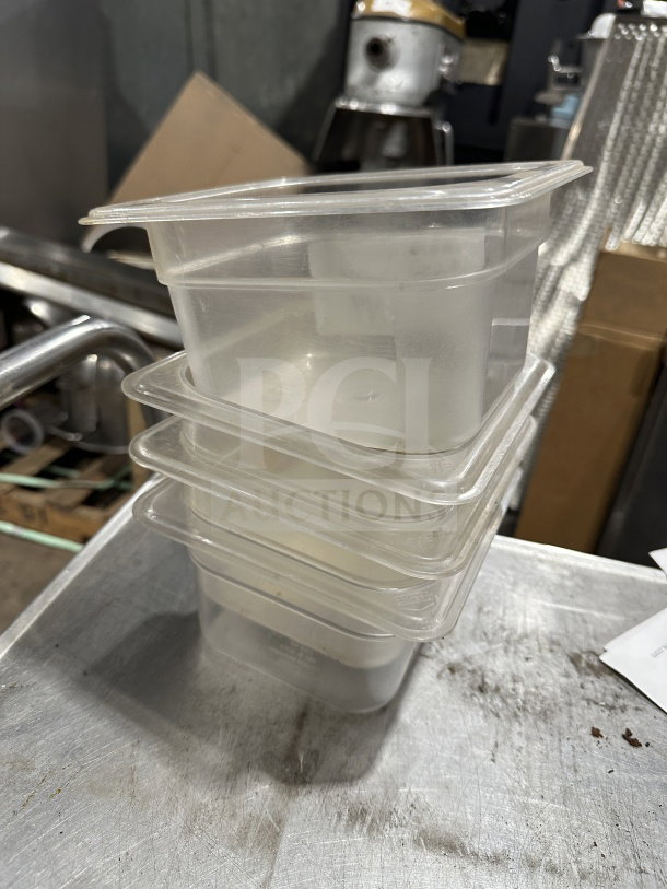 Stack of Plus commercial polypropylene translucent full-size food pans, showcasing sturdy construction, lightly used.