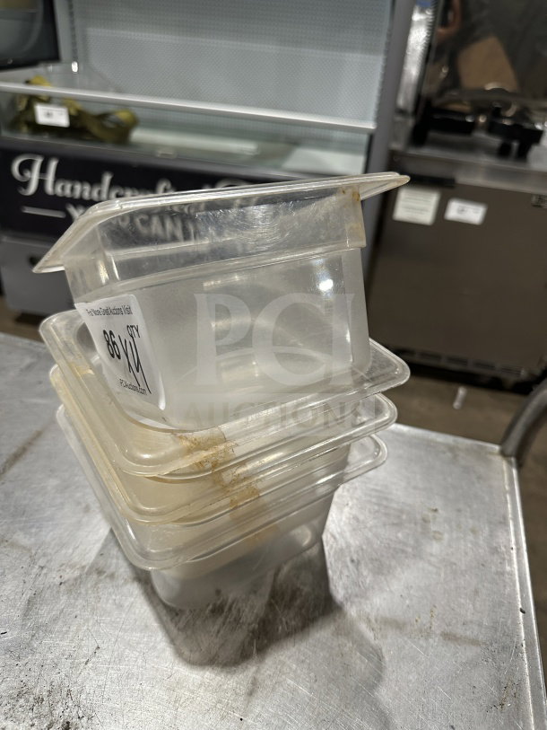 Plus Commercial Polypropylene translucent food pans, stack of four, with visible stains, labeled for auction bid increase.