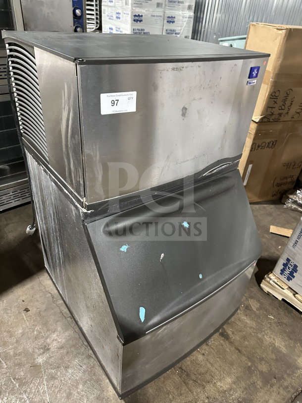 Manitowoc SY0304A stainless steel ice machine, electric, air-cooled, on legs. Serial number 110077763. Visible wear.