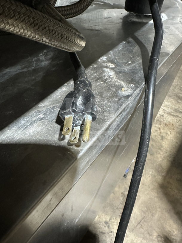 Black power plug connected to a braided gas hose, part of the Rational SelfCooking Center SCC 62G oven.