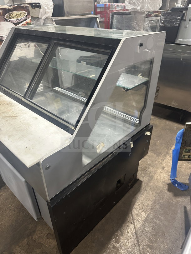 Senkar NETA4FT refrigerated bakery display case with clear glass and sliding doors. Black base, no compressor. Model SN: 200404011153.