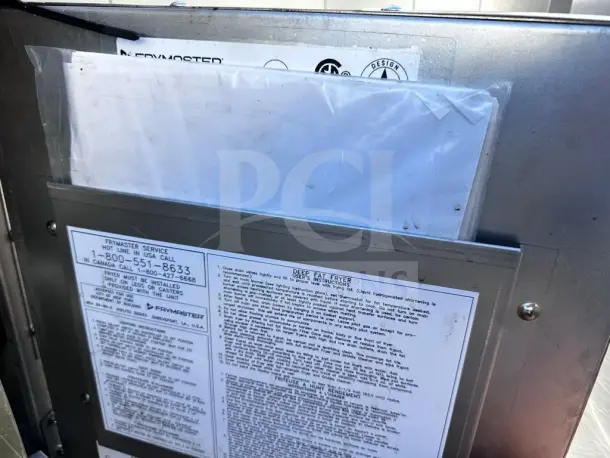 Frymaster 2FQG30U dual commercial fryer labels with service info, operating instructions, and certification marks visible.