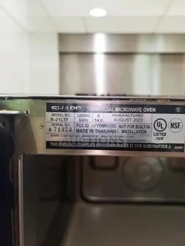 Sharp R-21LTF commercial microwave oven label, showing model, wattage, voltage, and NSF listing details.