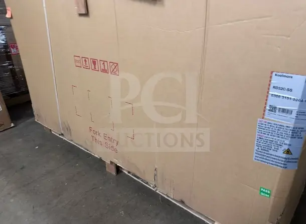 Boxed KoolMore RD32C-SS refrigerated deli display case, brand new. Label shows model and safety information.