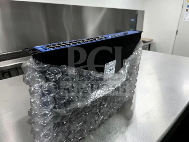 ADTRAN NetVanta 1234P 3rd Gen switch, bubble-wrapped, featuring 24-port Fast Ethernet PoE and quad Gigabit uplinks.