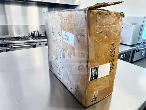 Sealed box for Wells 5P-MOD200TDM food warmer with visible shipping labels on stainless steel counter.
