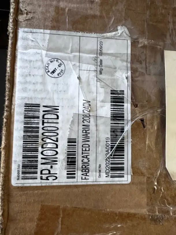 Label on a box for Wells 5P-MOD200TDM food warmer, showing model, serial number, and voltage details.