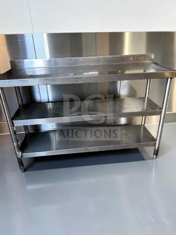 Commercial stainless steel work table, 55"x17", two undershelves, backsplash, excellent condition, model UNB-S-TBL-1353.