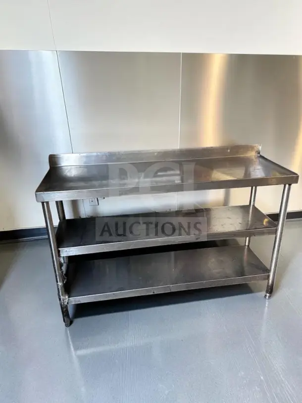 Stainless steel commercial work table, 55"x17", with two undershelves and backsplash, superior condition, model UNB-S-TBL-1353.