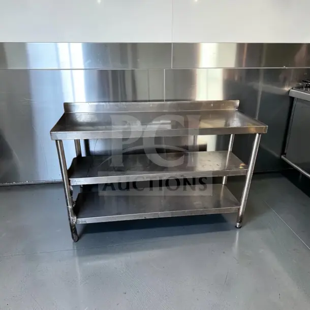 Stainless steel commercial work table, 55"x17", two undershelves, backsplash. Superior condition, model UNB-S-TBL-1353.